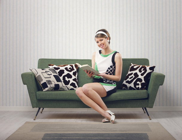 Girl sitting on the couch with a book - Foto, immagini