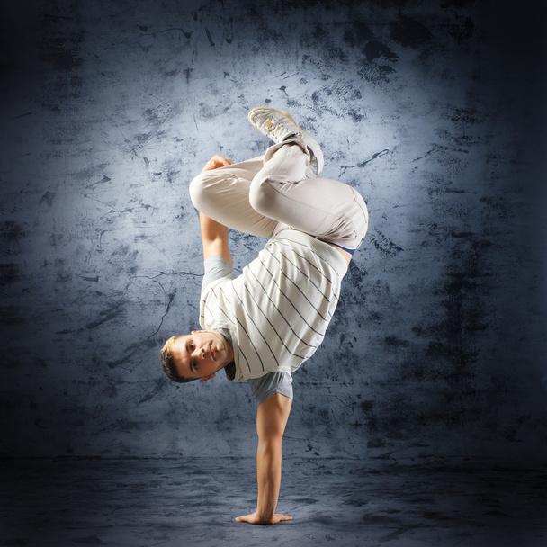 A young and fit dancer in modern clothes performing - 写真・画像