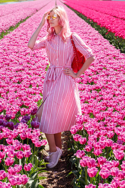 Smiling teenage girl walks through tulip field.Holland - Фото, зображення