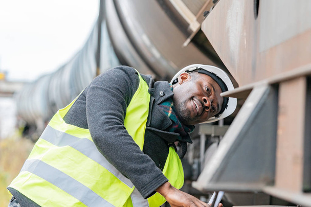 Africká americká kontruktér nosit bezpečnostní vybavení (přilba a sako) kontrola převodovky vlak - Fotografie, Obrázek