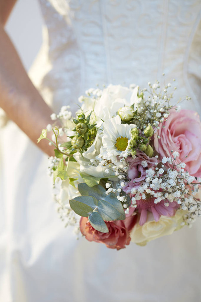 une mariée tenant son bouquet de fleurs le présentant devant elle
 - Photo, image