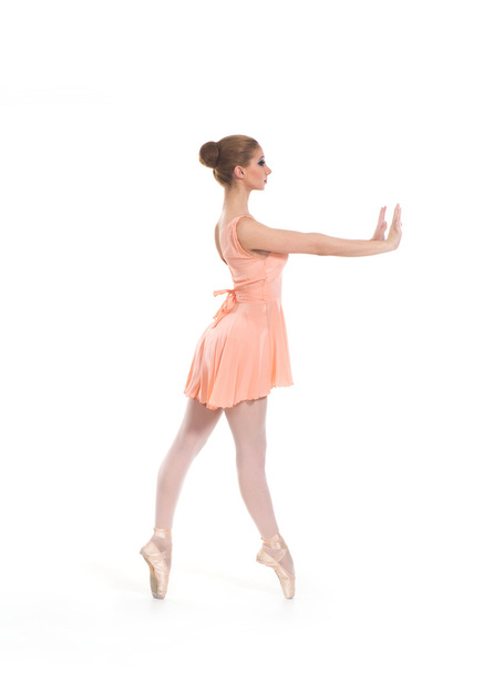 A young ballet dancer in a light dress on a white background - Foto, afbeelding