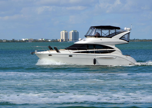 Weiße Luxus-Motorjacht kreuzt langsam auf der Küstenstraße von Florida vor dem Strand von Miami. - Foto, Bild