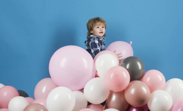 Chlapec a balóny. Dětské růžové a modré pozadí. Šťastný hry na hoře koule. Hra zdarma. Šťastné dítě. Zábavní centrum. Narozeniny dítěte. Roztomilé dítě. Dárky a výrobky pro děti - Fotografie, Obrázek