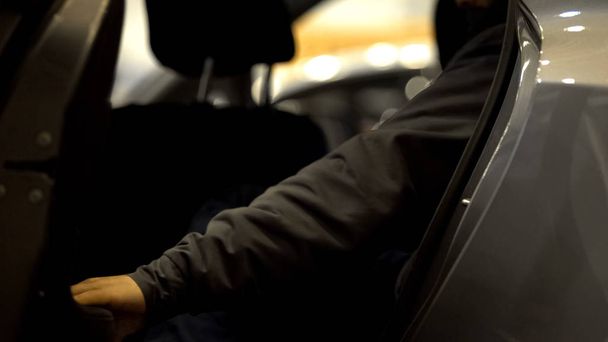 Miespuolinen matkustaja avaamassa ovea ja nousemassa autosta, taksipalvelu kaupunkiliikenne
 - Valokuva, kuva
