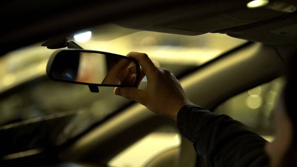 Hombre ajustando el espejo retrovisor en el coche, examen de licencia de conducir, rango de visibilidad
 - Foto, Imagen