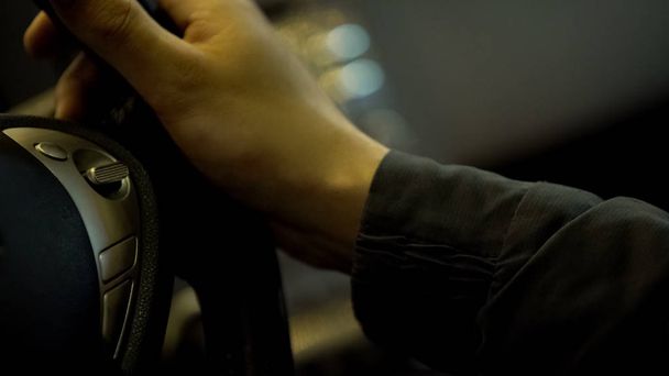 Driver holding electric car steering wheel, operating modern vehicle, close-up - Fotó, kép