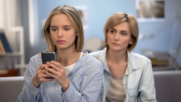 Addicted to smartphone daughter avoiding family talk with mother, naughty child - Photo, Image