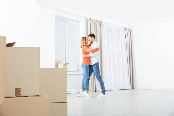 Happy couple dancing near moving boxes in their new house - Φωτογραφία, εικόνα