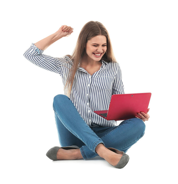 Emotional young woman with laptop celebrating victory on white background - 写真・画像