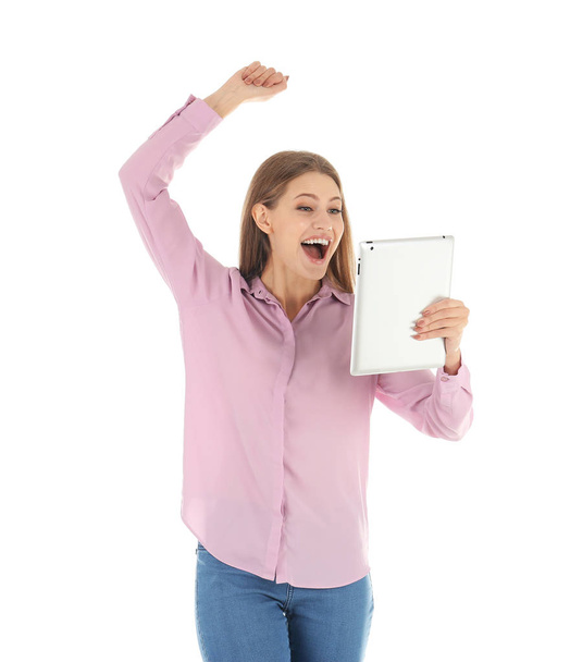 Emotional young woman with tablet celebrating victory on white background - Foto, imagen