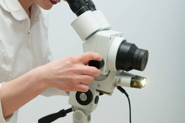 Κοντινό πλάνο γυναίκα γυναικολόγος συνεργάζεται με κολποσκόπιο - Φωτογραφία, εικόνα