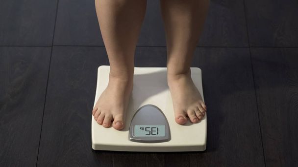 Healthy dieting, girl standing on bathroom scales to check weight, normal index - Fotografie, Obrázek