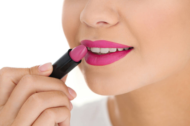 Beautiful woman applying lipstick on light background, closeup - Photo, Image