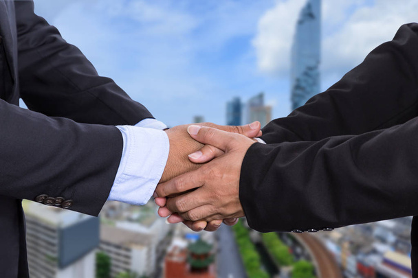 Empresários apertar a mão na reunião estilo asiático sobre fundo distrito de negócios
 - Foto, Imagem