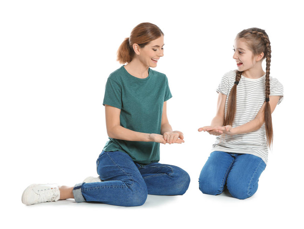 Mère malentendante et son enfant parlent avec l'aide du langage des signes sur fond blanc
 - Photo, image