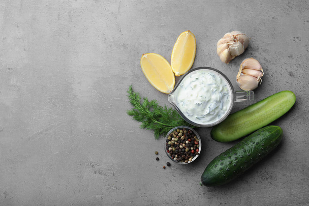 Cucumber sauce with garlic, lemon, dill and pepper on grey background, top view. Space for text - Foto, immagini