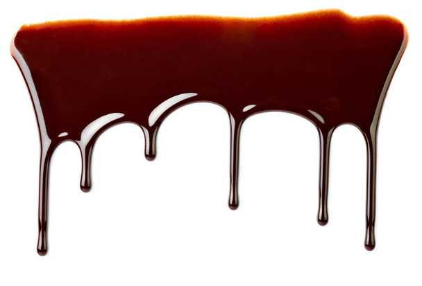 Close up van chocolade siroop lekken op witte achtergrond - Foto, afbeelding