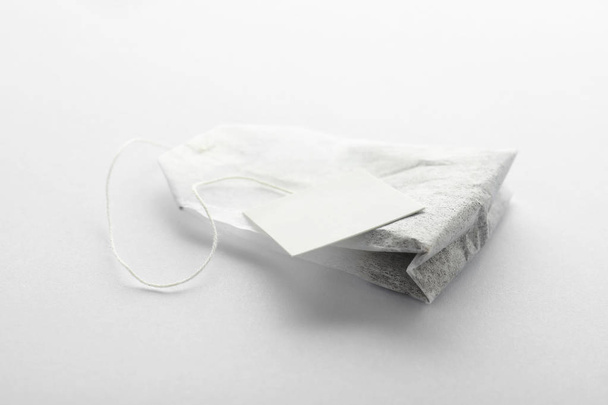 Unused tea bag with tag on white background - Foto, afbeelding