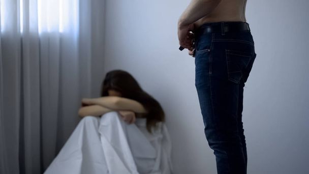 Male unzipping pants, frightened girl sitting in corner, sexual abuse kidnapping - Valokuva, kuva