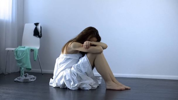 Raped lady sitting on floor, sexual assault victim, women rights, slavery - Foto, immagini