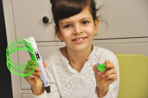 Una linda niña muestra lo que dibujó con su primera pluma 3D
. - Foto, imagen