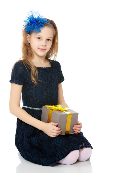 Cute little girl with a gift in hand. - Фото, зображення