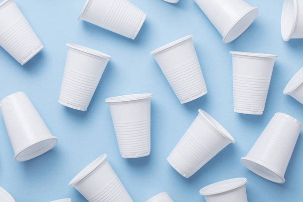 Single use white plastic cups on a blue background - 写真・画像
