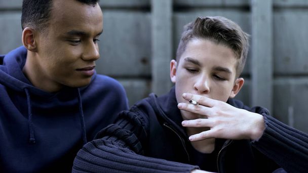 Bad company influence, teen teaching younger friend to smoke, first experience - Φωτογραφία, εικόνα