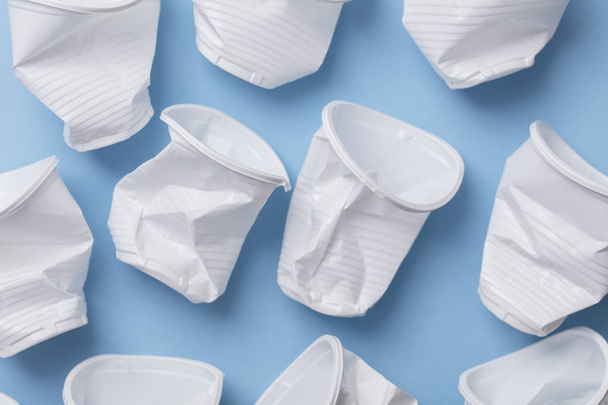 Single use white plastic cups on a blue background - Foto, immagini