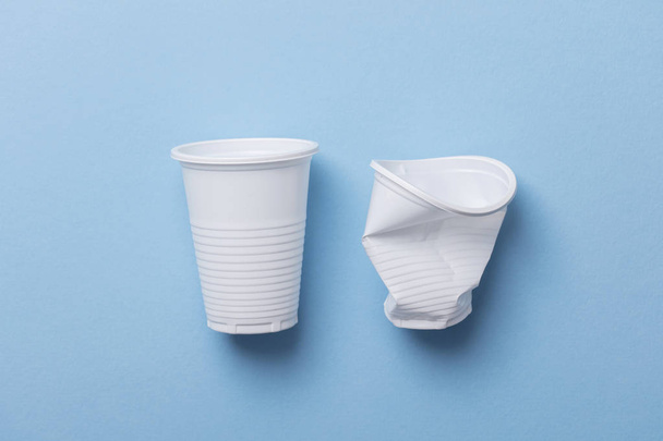 Tasses en plastique blanc à usage unique sur fond bleu
 - Photo, image