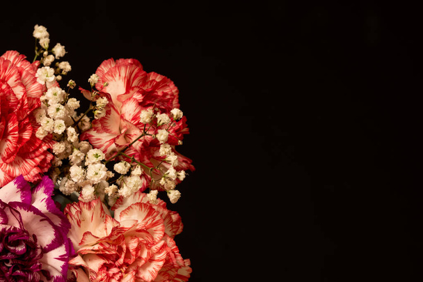 Decorated bouquet of carnations on a dark background with copy space - Zdjęcie, obraz