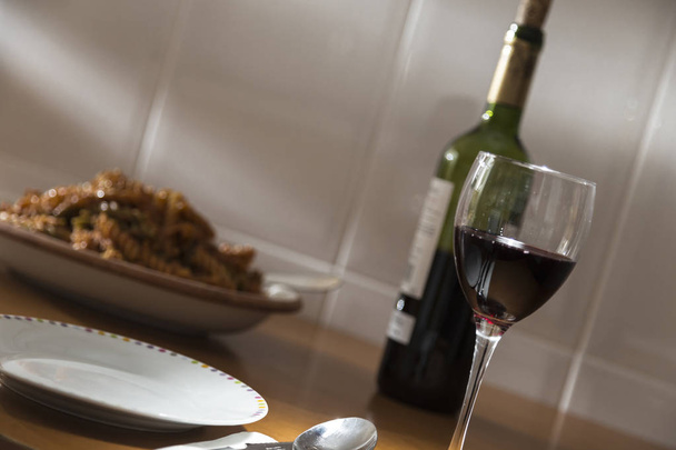 lasillinen viiniä ja makaronilautanen, pöytä valmistettu yksinäinen juhla
 - Valokuva, kuva
