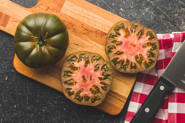 Dark brandywine tomatoes on cutting board. Top view. - Foto, Bild