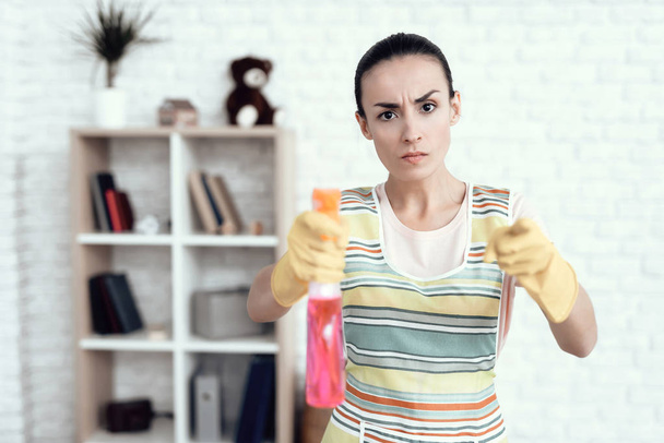 Een vrouw in een witte T-shirt poseren thuis met middelen voor het schoonmaken van het huis. - Foto, afbeelding