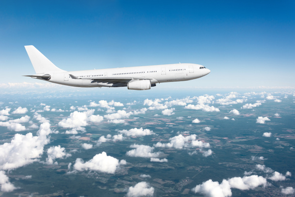 Avion de passagers atterrissant par beau temps avec un ciel bleu nuageux sur une piste
 - Photo, image