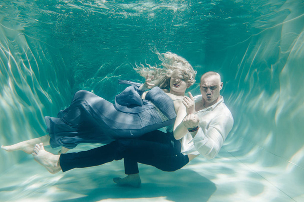 beautiful romantic couple of lovers hugging gently under water - 写真・画像