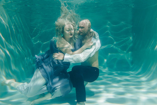 красива романтична пара коханців ніжно обіймається під водою
 - Фото, зображення