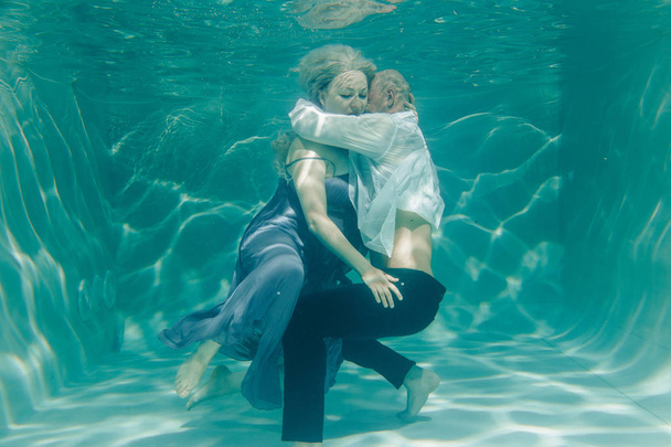 красивая романтическая пара влюбленных, нежно обнимающихся под водой
 - Фото, изображение