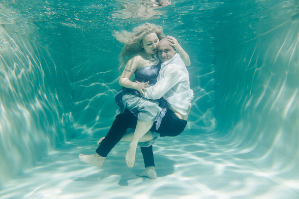 hermosa pareja romántica de amantes abrazándose suavemente bajo el agua
 - Foto, imagen