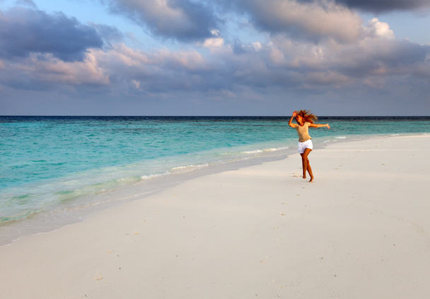The sporting woman runs on the seashore. Maldives - 写真・画像