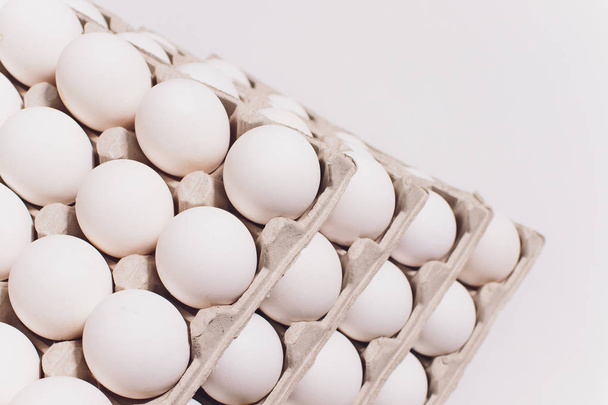 White eggs of a hen in harmless, cardboard packing on a white background. 5 packs. - Fotografie, Obrázek