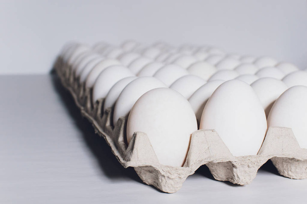 White eggs of a hen in harmless, cardboard packing on a white background. - Foto, Bild