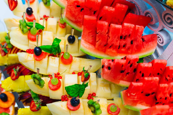 Una vista superior de fruta fresca que está decorada con otras frutas en el stand
 - Foto, Imagen