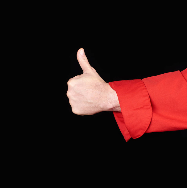 mano de chef masculino en uniforme rojo muestra un gesto de aprobación, como, fondo negro
  - Foto, imagen