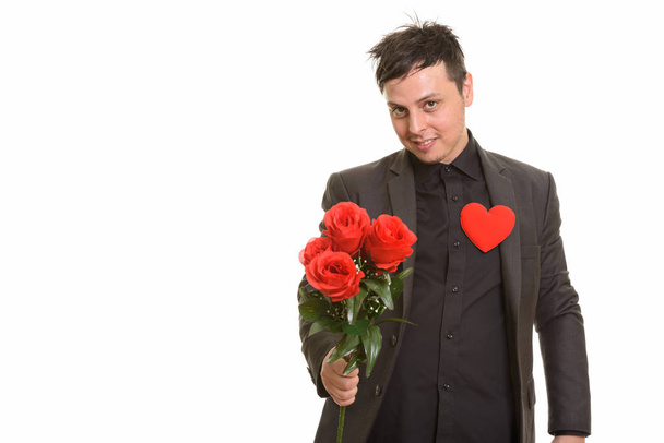 Studio shot of Caucasian businessman giving red roses ready for  - Fotó, kép
