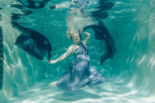 παχουλός σέξι γυναίκα σε γκρι μακρύ φόρεμα υποβρύχιο κολύμπι πάνω της το βράδυ διακοπές και Απολαύστε με relax - Φωτογραφία, εικόνα