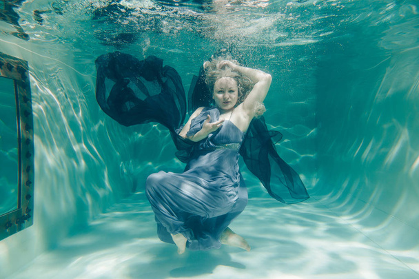chubby sexy woman in grey evening long dress swimming underwater on her holidays and enjoy with relax - Photo, Image