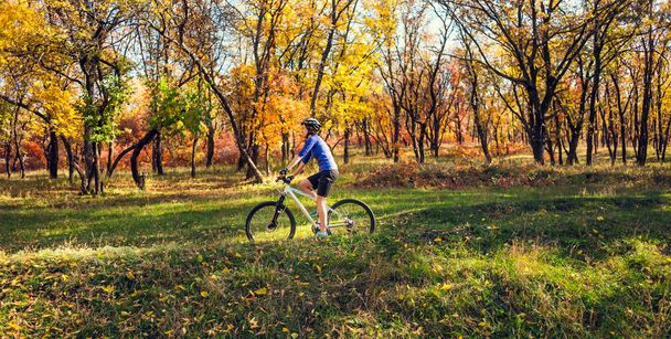 Ormanda bisiklet. Kız bir orman iz üzerinde bisiklet sürmek. Kadın parkta bisiklet sürme. Bisiklet touring. Doğal yerlere seyahat. Sonbahar ağaçlar. - Fotoğraf, Görsel