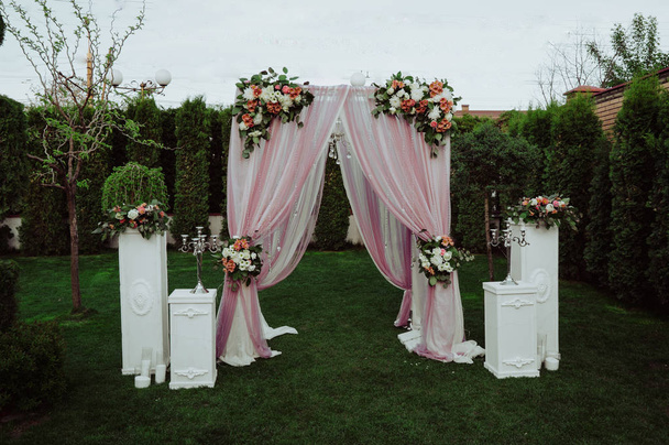 Καμάρα ροζ γάμου διακοσμημένη με λουλούδια στον κήπο - Φωτογραφία, εικόνα